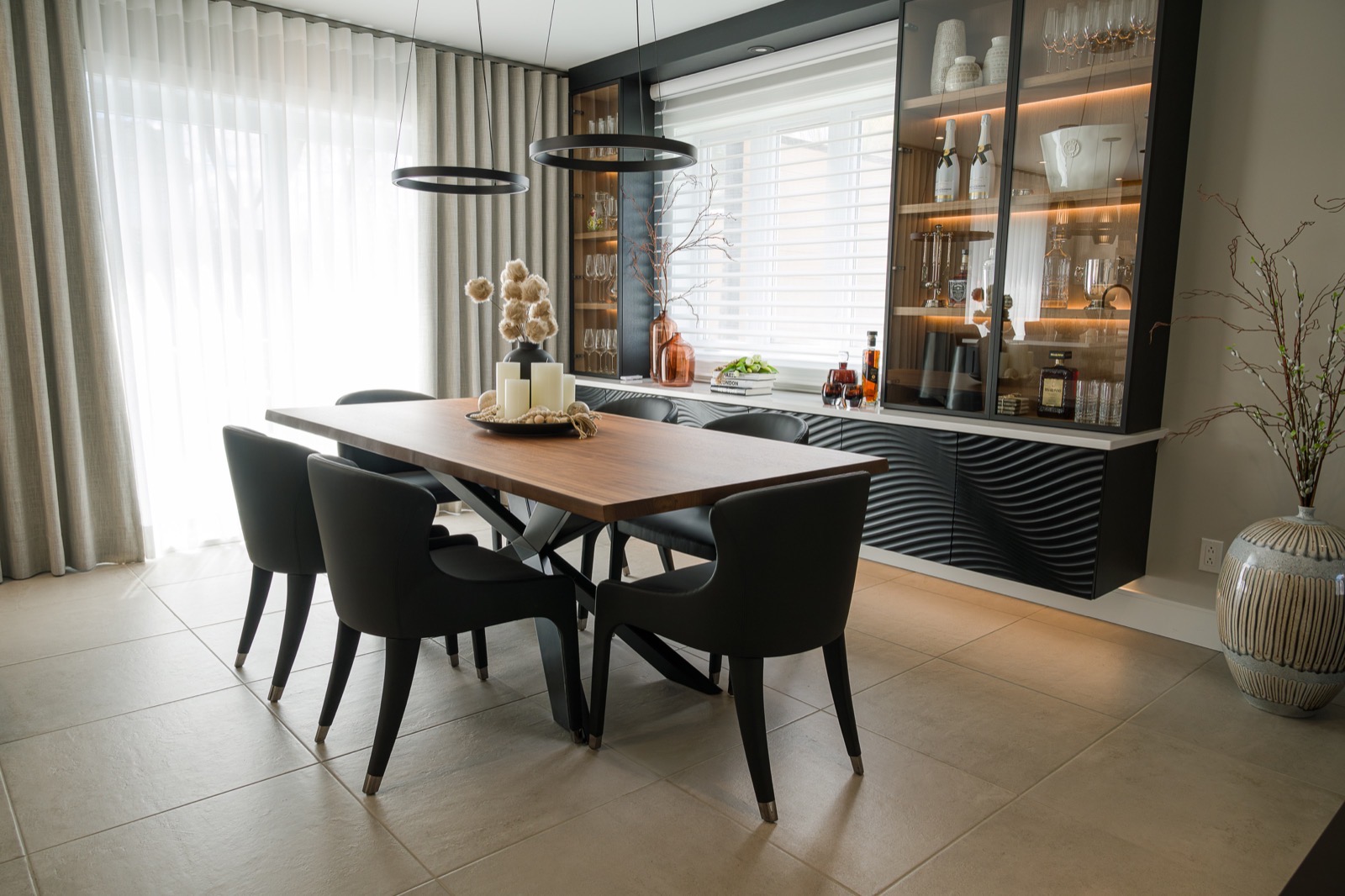 Salle à manger avec table en bois, chaises noires et mobilier intégré texturé