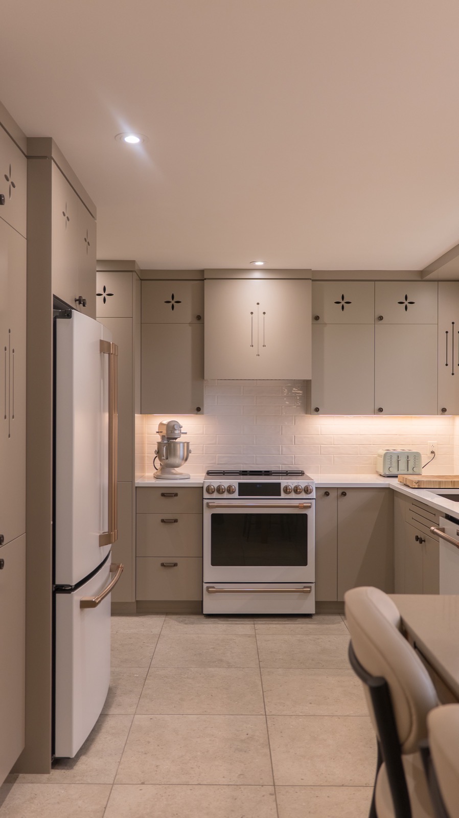 Cuisine rénovée sur mesure avec armoires taupe, électroménagers blancs et éclairage intégré