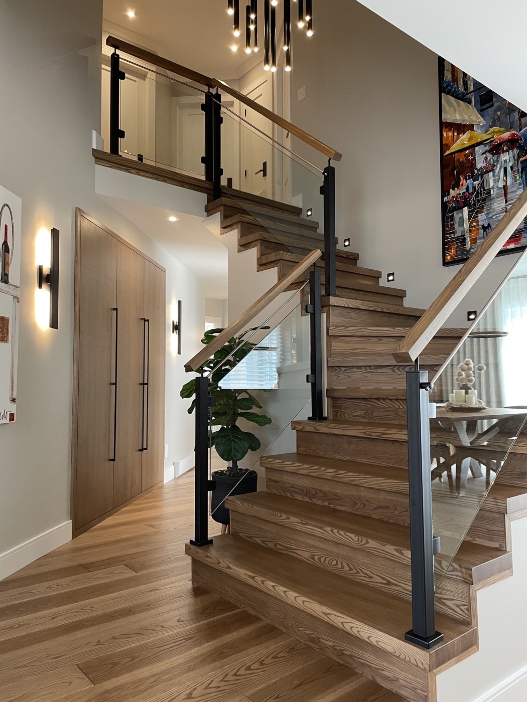Escalier en bois avec garde-corps en verre et rangement intégré assorti
